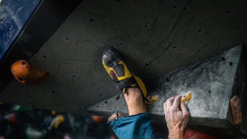 A climber using a heel hook on a steep overhang